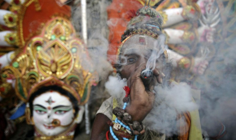 A Hindu holy man, or Sadhu, smokes ganja as he participates in a religious ceremony in Bhubaneswar, India, in October 2012. (Biswaranjan Rout, Associated Press file)